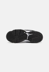 Čierna guma podrážky topánky s textúrovaným vzorom obsahujúcim kruhové a trojuholníkové gripy; výrazné biele logo Jumpman vyrazené na oblúku.