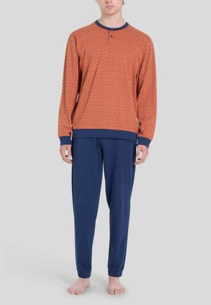 Maglietta arancione a maniche lunghe con dettagli blu e piccoli motivi, abbinata a pantaloni blu navy, realizzati in tessuto morbido, taglio rilassato.