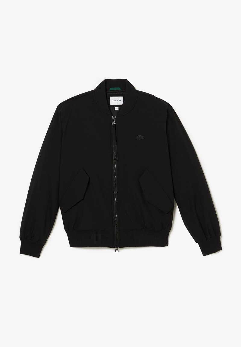 Veste bomber noire avec fermeture éclair à l'avant, poignets et ourlet côtelés, deux poches latérales et un logo discret sur la poitrine. Finition en tissu lisse.