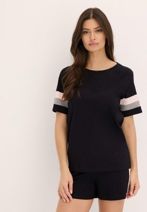 Haut noir à manches courtes avec des rayures pastel contrastées sur les manches. Fabriqué en tissu lisse, associé à un short noir assorti.