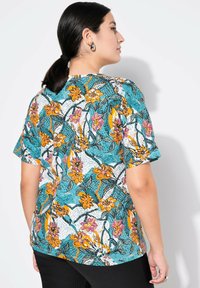 Korte mouwen overhemd met bloemenpatroon in turquoise, voorzien van oranje en roze bloemen met zwarte omlijning, textuurontwerp en een relaxte pasvorm.