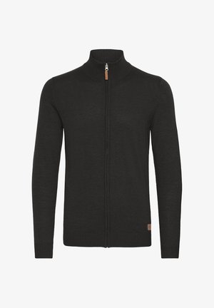 Svart hettegenser med glidelås, høy ribbestrikket krage, teksturert strikket stoff, ribbestrikkede mansjetter og kant, samt et lite lærmerke på den nederste siden.