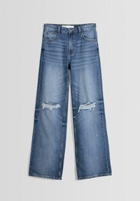 Ljusblå vida jeans i denim med slitna detaljer vid knäna, fem fickor och klassisk knapp- och dragkedjestängning.