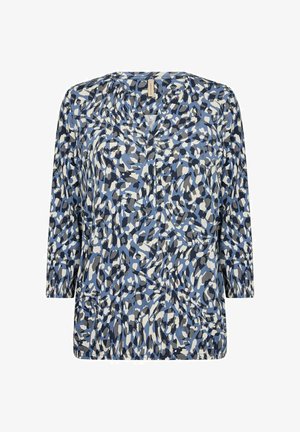 Blaue Bluse mit V-Ausschnitt und Dreiviertelärmeln. Sie hat ein abstraktes Muster in verschiedenen Blautönen, Grau und Weiß.