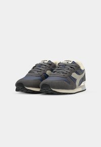 Scarpe sportive grigie e blu navy in materiali scamosciati e in rete, con colletto imbottito, chiusura con lacci e suola in gomma.