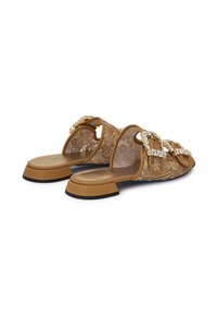 Sandali scivolosi color bronzo con un design in pizzo, dotati di due ampie cinghie con fibbie in strass. Sole in gomma, tacco piatto, dettagli con motivi intricati.
