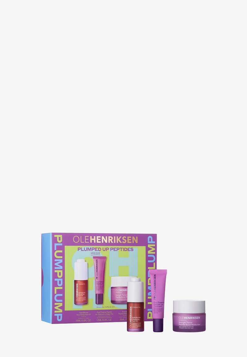 Das Ole Henriksen Plumped Up Peptides Set in einer bunten Verpackung zeigt rote, lila und weiße Tuben sowie ein Glas mit glatter Textur.