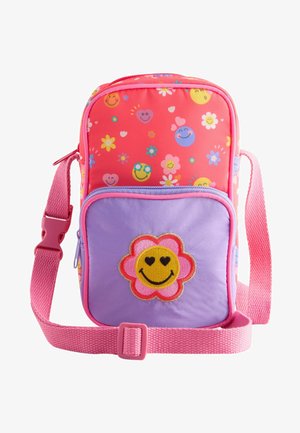 Bolso cruzado multicolor con patrones florales y sonrientes, que presenta un diseño en rosa y púrpura, correa ajustable y detalle de flor bordada.