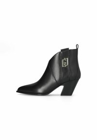 Stivaletto in pelle nera con punta appuntita, tacco medio e logo in metallo decorativo sul lato. Texture liscia e design elegante.