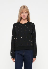 Sweat à capuche noir avec motif de cœurs dorés, col rond, manches longues et poignets côtelés. Tissu doux avec une coupe décontractée.