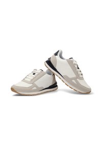 Zapatillas de cuero y ante blanco y gris claro, con un talón negro, texturas contrastantes y una suela de goma con una pisada marrón.