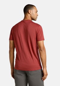 Rotes T-Shirt mit kurzen Ärmeln, Rundhalsausschnitt, tailliertem Schnitt und strukturiertem Stoff. Von hinten mit einfachen Nähdetails gezeigt.