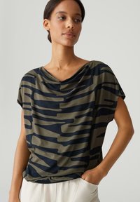 Korte mouwen top in olijfgroen en marineblauw met een gedrapeerde halslijn, voorzien van een camouflagepatroon en een relaxte pasvorm. Gladde stoftextuur.