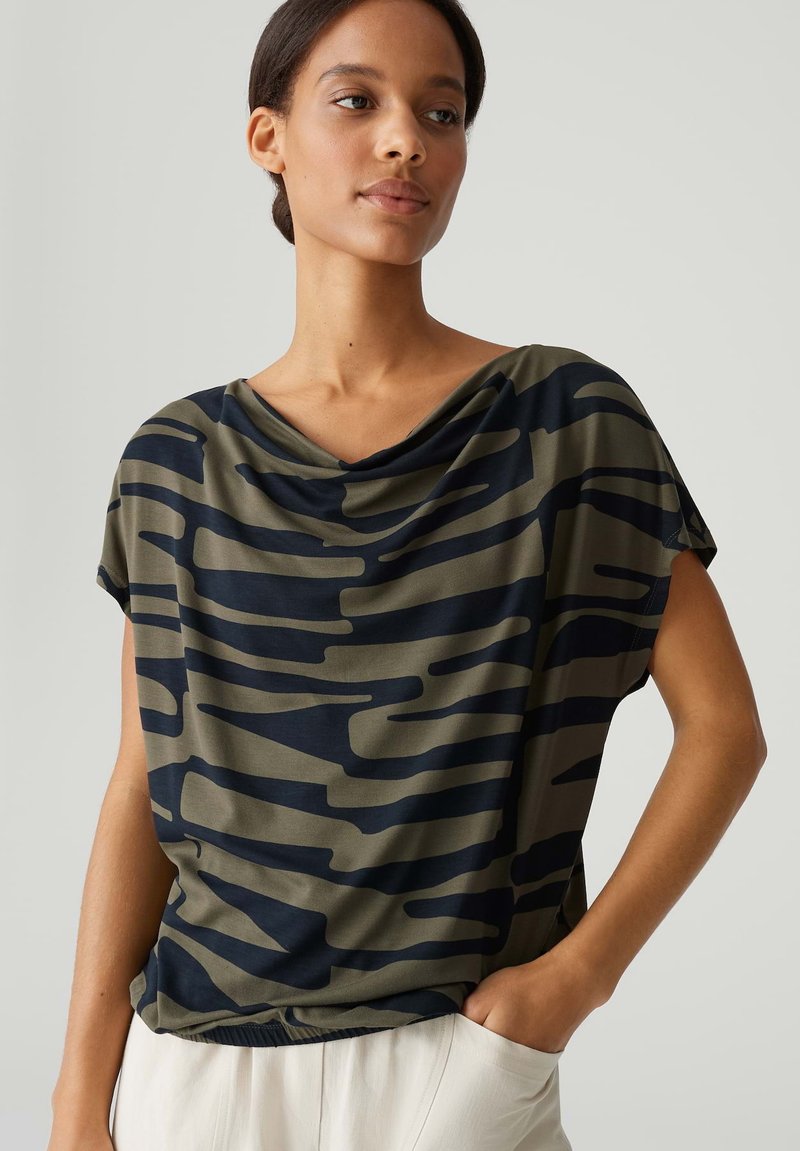 Korte mouwen top in olijfgroen en marineblauw met een gedrapeerde halslijn, voorzien van een camouflagepatroon en een relaxte pasvorm. Gladde stoftextuur.