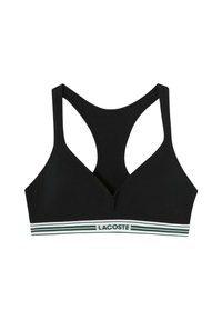 Sujetador deportivo negro con escote en forma de V y tirantes anchos estilo racerback. Presenta una banda a rayas verde y blanca con el logotipo de "LACOSTE". Textura suave.