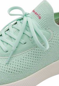 Baskets vert menthe avec une tige en maille texturée, des lacets assortis, et une semelle en caoutchouc blanche lisse. Présente un marquage minimal en rose.