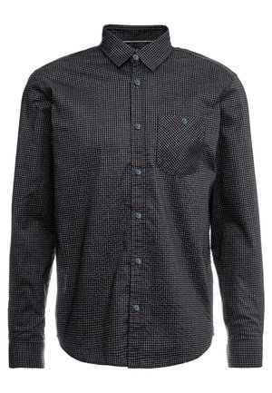 Chemise à manches longues à carreaux noirs et gris, avec col et une poche poitrine boutonnée.