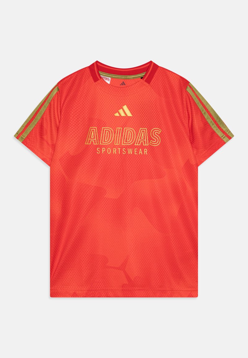 Sarkana sporta t-kreksa ar sieta tekstūru, piedāvā zelta "ADIDAS SPORTSWEAR" logotipu un zaļus svītrām uz piedurknēm. Regulējams kakla izgriezums.