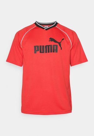 Rød kortermet sportstrøye laget av pustende stoff. Har svart Puma-logo og kontrastfargede detaljer i svart og hvitt på kragen.