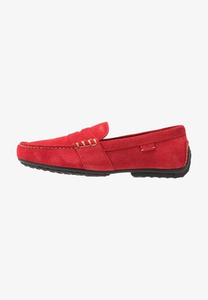 Mocassin homme en daim rouge avec semelle en caoutchouc noire et surpiqûres beige, vu de côté.