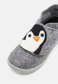 Gray felt slipper featuring a penguin design on the front with a white heart-shaped outline, orange beak, and black accents. Rubber sole.