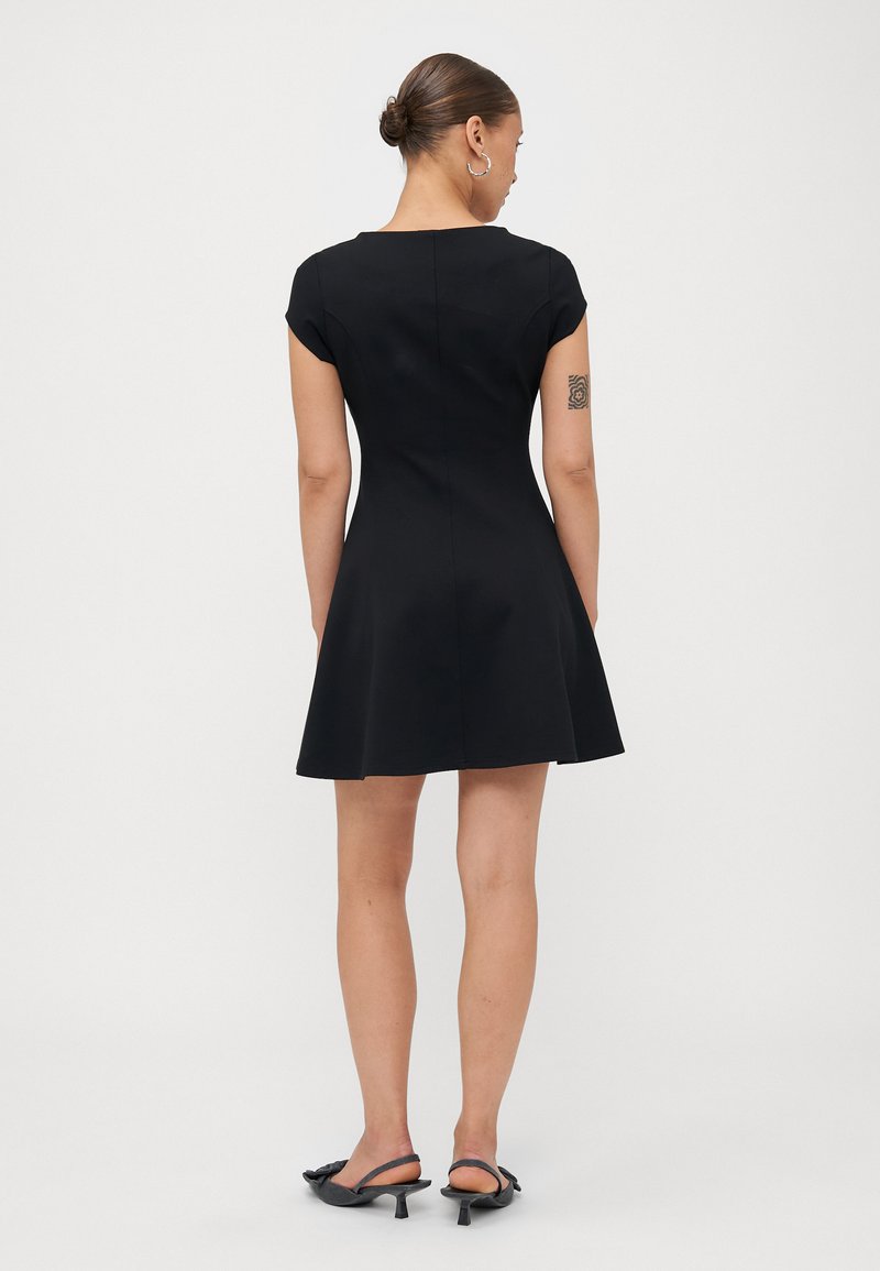 Robe noire à manches courtes avec un corsage ajusté et une jupe évasée, fabriquée en tissu lisse ; elle présente un col rond et des coutures discrètes.