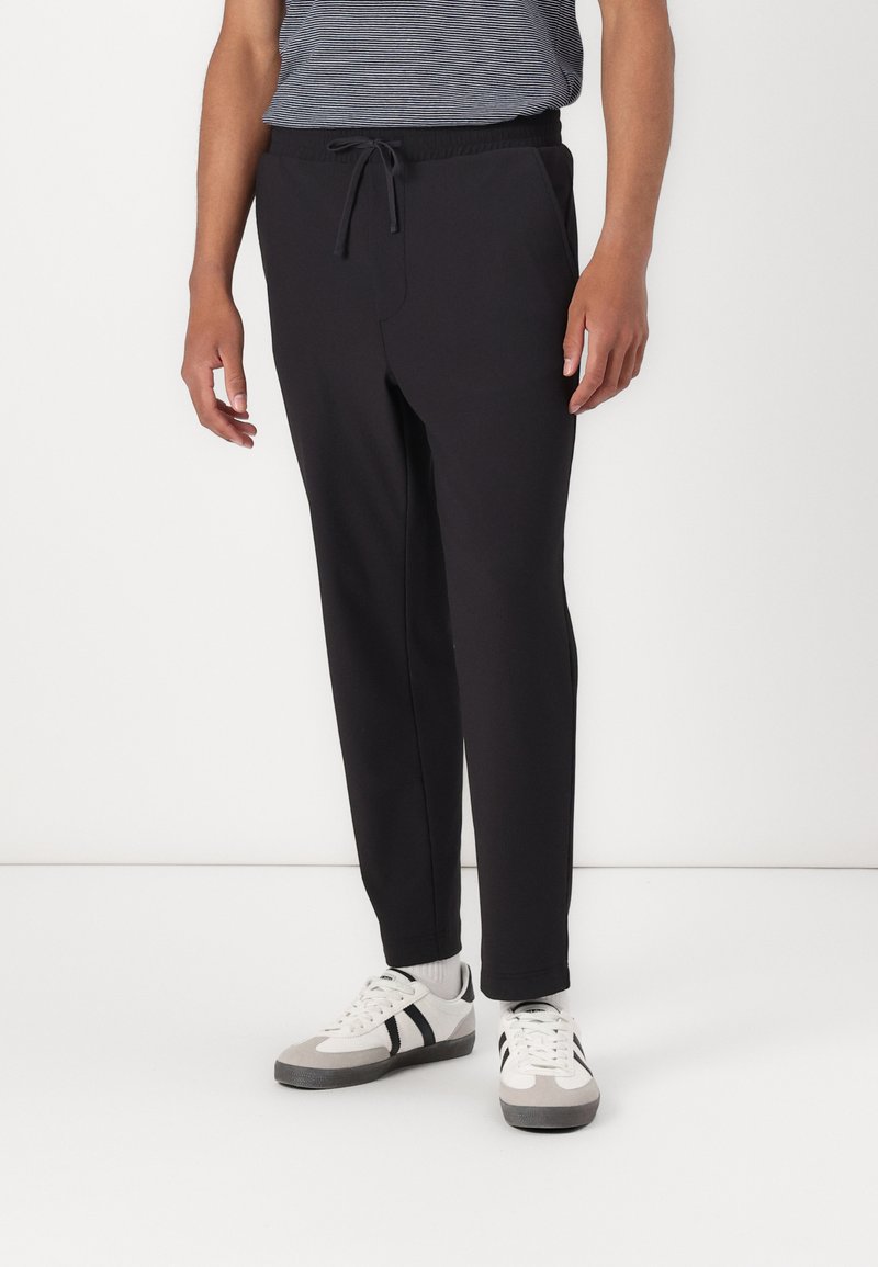 Sorte joggebukser med elastisk midje og snor, med en avslappet passform, frontlommer og glatt bomullsblanding.