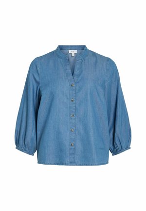 Blå denimbluse med fem knapper foran, trekvartlange puffede ermer og rund krage med en lett V-formet åpning.