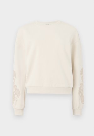 Cremefarvet sweatshirt med rund hals, der har blomstermønster broderet på ærmerne. Blød tekstur og cropped design med ribbede manchetter.