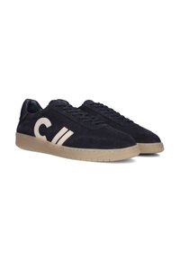 Marineblauwe suède sneakers met een gestructureerd oppervlak, voorzien van een beige logo en strepen. Ronde neus en rubberen zool met een gestructureerde grip.