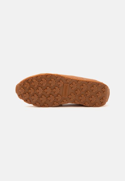 Semelle de chaussure marron avec des crampons en forme de feuille d'érable en relief et un logo rectangulaire portant la mention "DSQUARED2" au centre.