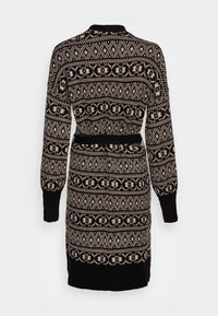 Svart och beige stickad klänning med geometriska och blommiga mönster, långa ärmar, ribbade muddar och en figursydd midjebälte, visad bakifrån.