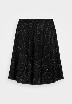 Μαύρη φούστα με περίπλοκους κεντημένους και διακοσμημένους ραφές σε κάθετες γραμμές, με φουσκωτό τελείωμα για πρόσθετο όγκο και κίνηση.