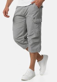 Grijze cargoshorts van lichtgewicht stof, met zijzakken, knielange snit en gestikte details. Draag met witte sneakers.