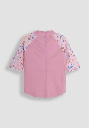 Różowa koszulka ochronna z krótkim rękawem, z jednolitą korpusem i kolorowym wzorem na rękawach w motywy podwodne. Z tyłu znajduje się zamek błyskawiczny, ułatwiający zakładanie.