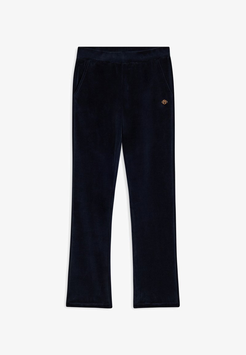 Pantalones de terciopelo azul marino con un diseño de pierna recta, dos bolsillos laterales y un pequeño emblema dorado en la cintura delantera. Textura suave.
