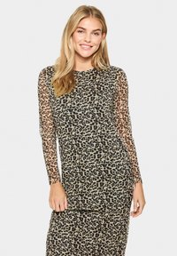 Leopardmönstrad klänning med långa genomskinliga ärmar, mjukt tyg, rundad halsringning och en figursydd silhuett. Färgerna inkluderar beige, svart och brun.