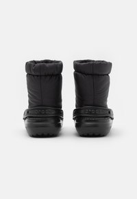 Bottes d'hiver noires avec une tige rembourrée, un poignet élastique et une semelle en caoutchouc durable dotée d'une semelle texturée et d'un logo embossé sur la bande.