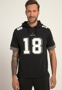 Felpa nera a maniche corte con grande numero bianco "18" sul davanti, dettagli grigi sulle maniche e tasca a canguro frontale.