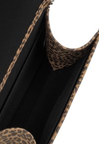 Borsa nera con interno e rifiniture a stampa leopardo, caratterizzata da una texture liscia e una forma strutturata. All'interno presenta un design spazioso.