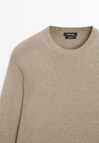 Beige cotton knit sweater with round neckline and ribbed collar, sleeve, and hem, labeled Massimo Dutti.