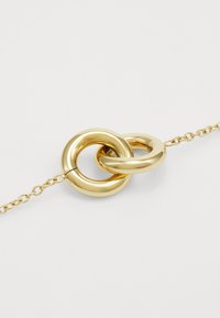 Bracciale color oro con due anelli circolari intrecciati, finitura lucida e un design delicato a catena.