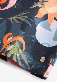 Lillemustriga kangas, millel on värvikad taimed ja abstraktsed kujundid tumedal taustal, mille külge on kinnitatud kuldne dekoratiivne aksent.