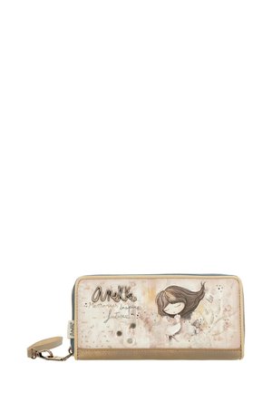 Cartera de cuero sintético con un diseño beige claro que presenta una ilustración de una chica, detalles en plata y cierre de cremallera. Dimensiones aproximadamente 20x10 cm.