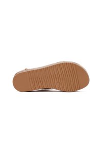 Brown rubber outsole with horizontal ridges and a circular logo. The design features smooth edges and a rounded toe.
