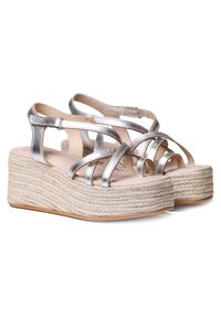 Sandalias plateadas con tiras y una amplia plataforma de esparto, que presentan detalles de yute trenzado y una plantilla suave y acolchada.