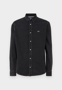 Svart denimskjorta med knäppkrage, långärmad, fem knappar och en liten logotyp på bröstet. Detaljer med kontrastsömmar.