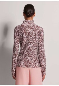Langärmliges Rollkragenoberteil in Hellrosa mit einem Paisleymuster in Burgunderrot und Weiß. Rippstruktur entlang des Kragens und der Ärmelbündchen.