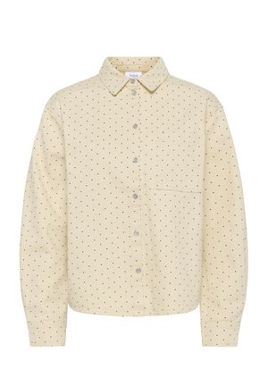 Beežist puuvillast nööbitav triiksärk mustade täpikestega, rinnatasku ja klassikalise kraega pikkade varrukatega.