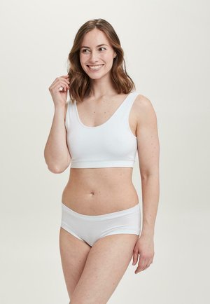 Hvid blød bomulds-bralette med brede stropper og et matchende par boyshorts. Begge har en glat tekstur og et minimalistisk sømdesign.